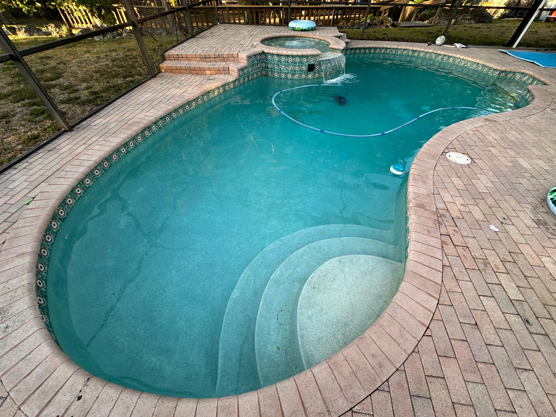Same pool after service with clear blue water and visible steps
