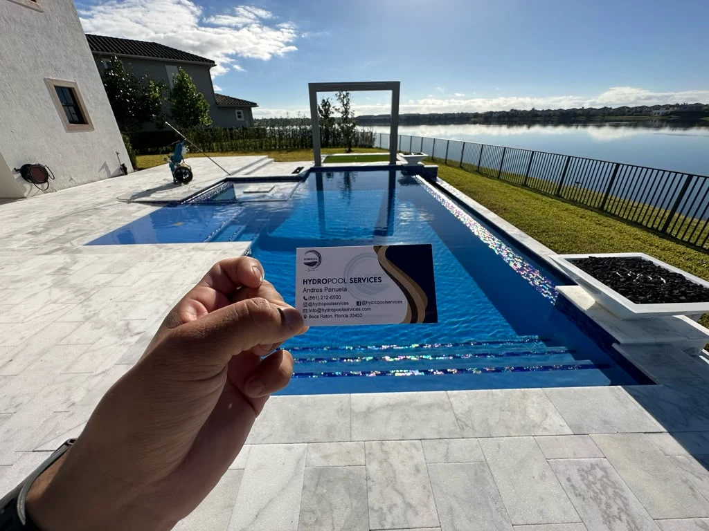 Hydropool business card held in front of a serviced blue swimming pool
